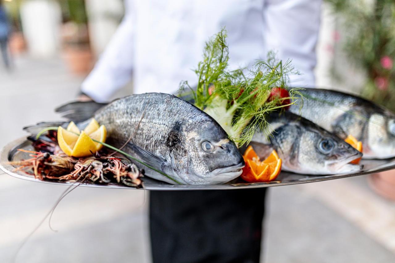 灯塔高尔夫和spa酒店 巴尔奇克 外观 照片 A waiter holding a platter of fish
